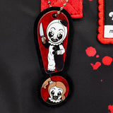 Reversible and convertible horror movie Terrifier 2 tote bag showcasing a split black-and-white design with red blood splatters, a bloody meat cleaver bag charm, and an Art the Clown charm