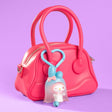 My Melody Sanrio Ghostly Appearance Figure Bell Keychain styled as cute bag charm attached to handle of hot pink leather purse, perfect for Halloween accessory or kawaii bag decor