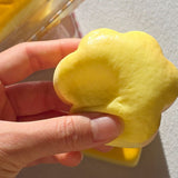 Hand squeezing a cute golden-brown cat paw pastry squishy toy showing doughy elasticity and soft squishy texture, perfect kawaii gift and Christmas stocking stuffer