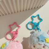 Two star-shaped keychains, one pink and one blue, on a light surface with a textured background.