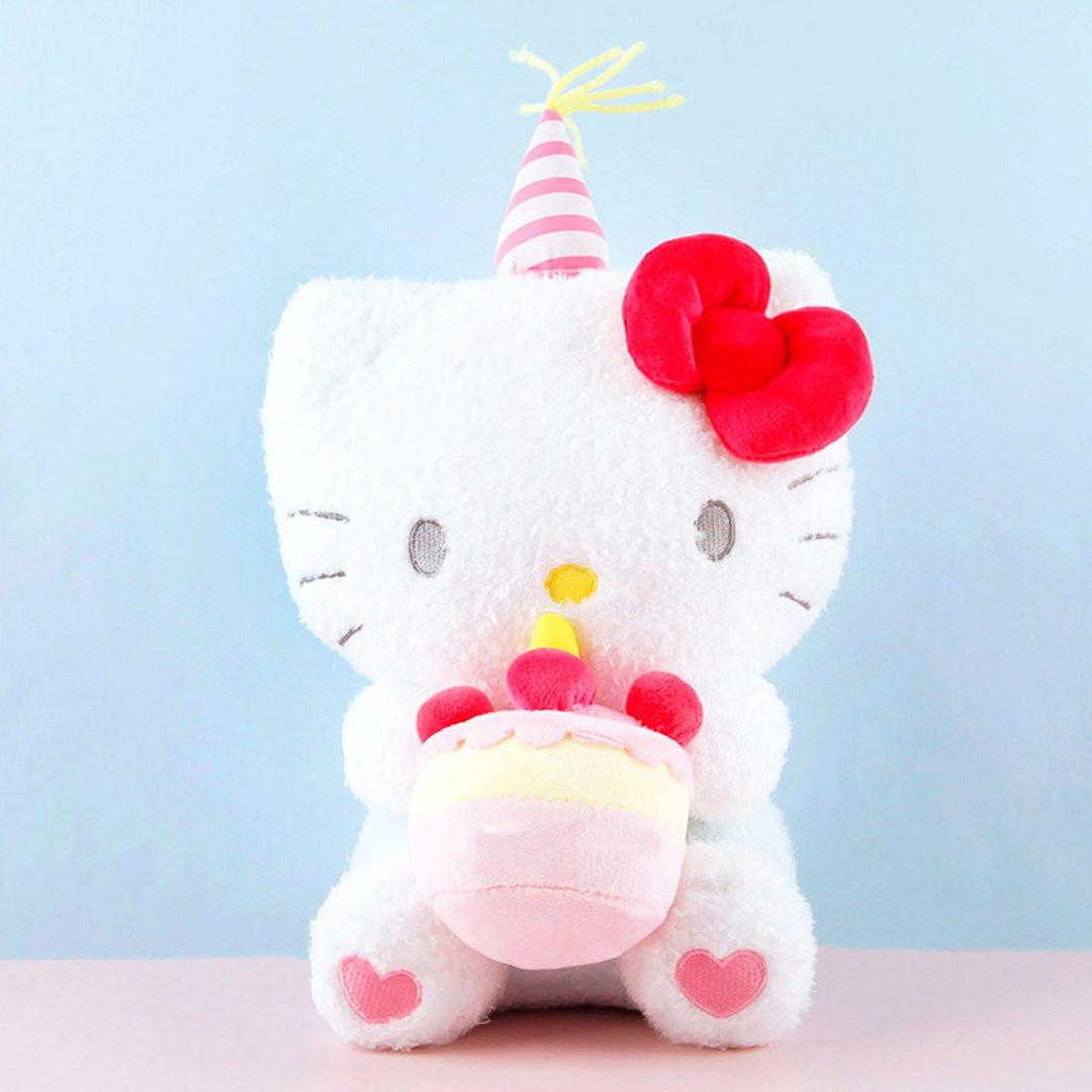 Officially licensed Sanrio Hello Kitty plush wearing a charming white party hat topped with a bright yellow tassel, and holding a cake for celebrating a special day.