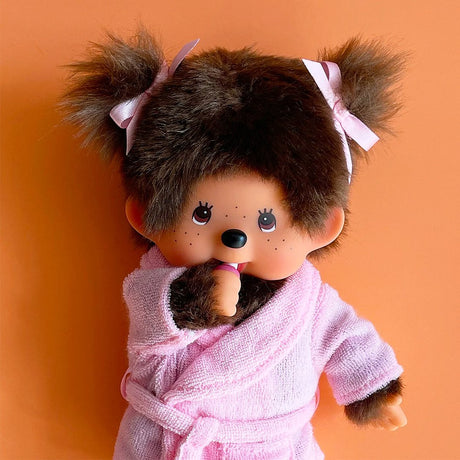 Official Licensed Monchhichi: Close-up of pink bathrobe doll with signature PVC face and soft fur, perfect as an authentic gift.