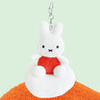 Plush keychain of Miffy character in an orange outfit sitting on the cloud