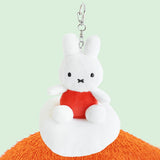 Plush keychain of Miffy character in an orange outfit sitting on the cloud