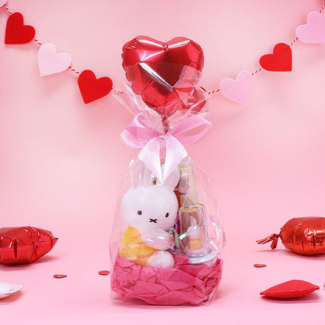 Official Miffy Valentine's Day Plush Gift Set in a clear ribbon package with a heart balloon. Includes a small yellow miffy holding a flower and a collectible figure stamp, sticker, and notepad perfect for Kawaii aesthetic Valentine's Day gift ideas