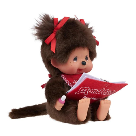 Officially Licensed Sekiguchi Monchhichi Sitting & Reading Girl 7 Inch Plush Doll reading a red Monchhichi storybook, featuring red bib and red hair ribbons on twin pigtails, perfect Christmas gift and holiday present for Monchhichi fans