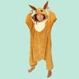 Official Pokémon Eevee Kids Costume Kigurumi Onesie Jumpsuit worn by a young model holding the pointed long ears. Features a soft light-brown fleece body, fluffy cream collar fluff, and an Eevee character face hood. Perfect for kids' Halloween costumes, cosplay party suits, sleepovers, and birthday gifts