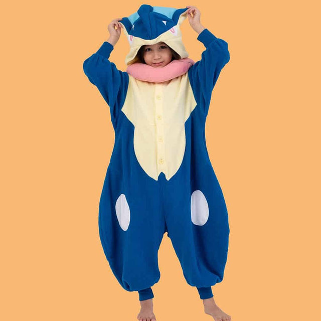 Official Pokémon Greninja Kids Costume Kigurumi Onesie Jumpsuit worn by a young model holding the hooded ears. Features a soft blue fleece body, cream chest panel, white knee spots, and a plush pink tongue scarf collar. Perfect for kids' Halloween costumes, cosplay party suits, sleepovers, and holiday gifts.