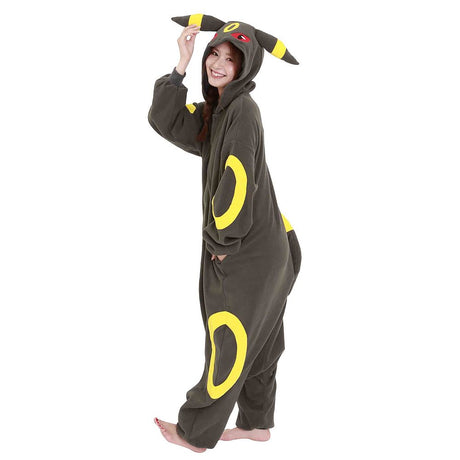 Official Pokémon Umbreon Costume Kigurumi Onesie Jumpsuit worn by a model holding the hooded ears. Features a soft black fleece body with yellow oval patterns and red character eyes. An ideal cosplay outfit for Halloween costumes, cozy sleepover nights, and year-end holiday party loungewear for adult Pokémon fans