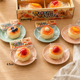 Individually packaged pancake squishy toys with Korean labels laid out next to a retail display box on small pastel plates, ideal party favor goodie bag filler and Christmas holiday gift set