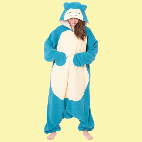 Model posing in Pokémon Snorlax Fleece Kigurumi Onesie Costume adjusting sleeping Snorlax hood with ears, cozy unisex anime lounge wear, ideal holiday present and Halloween costume