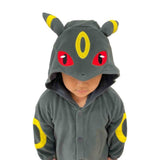 Close-up front view of child wearing Pokémon Umbreon Kids Fleece Kigurumi Onesie showing detailed hood with red eyes, yellow forehead ring, and tall Umbreon ears, perfect for Halloween dress-up and holiday stocking stuffer