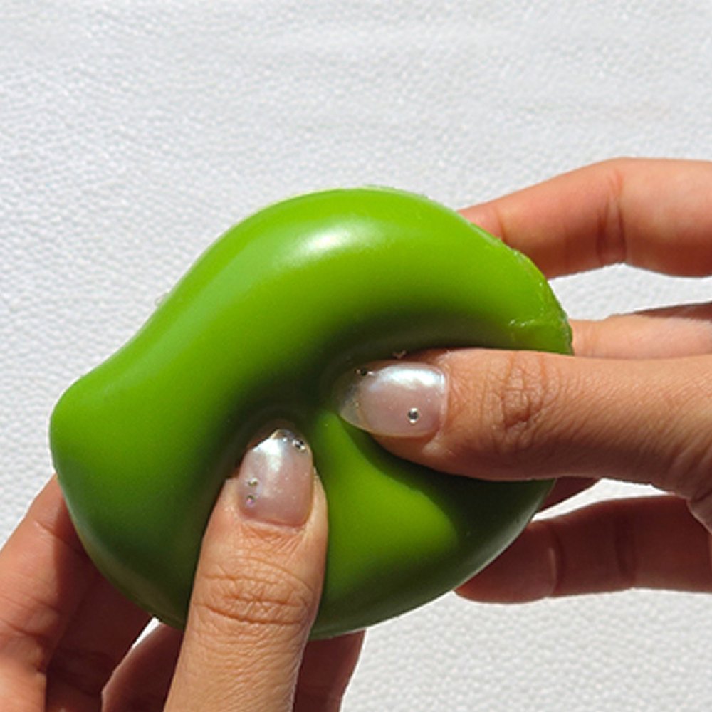 Squeezing open a green Sugar Mango Crunch Slime showing soft white stretchy slime filled with colorful crunch beads and yellow toppings inside, perfect Christmas gift and stress relief sensory toy