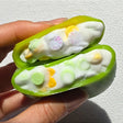 Squeezing open a green Sugar Mango Crunch Slime showing soft white stretchy slime filled with colorful crunch beads and yellow toppings inside, perfect Christmas gift and stress relief sensory toy